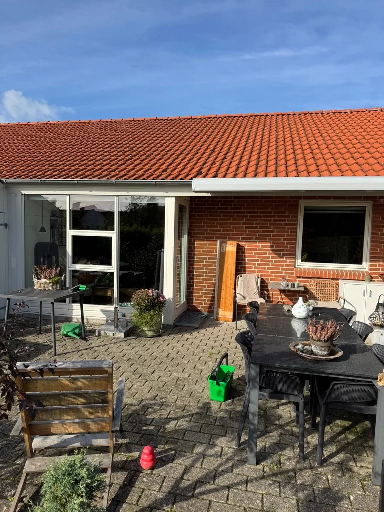 Vinduespudsning ved rækkehus i Årslev med glasparti og vindue mod terrassen