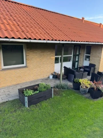 Vinduespudsning ved hus i Årslev med vinduer og glasdøre mod terrassen